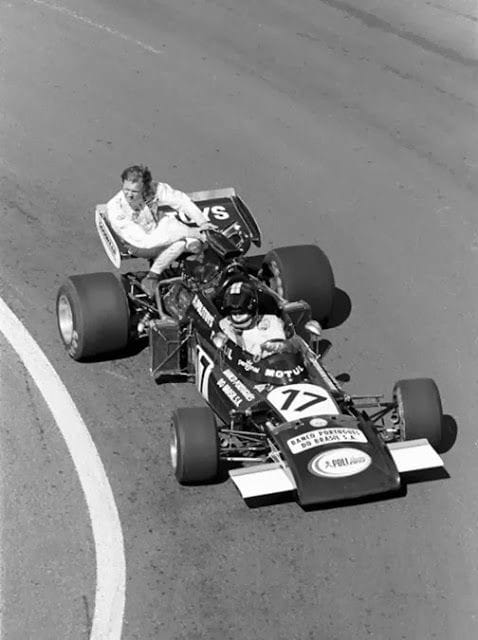 Ronnie Peterson, March, gets a lift back to the pits with Carlos Pace, Frank Williams Racing Cars, during practice for the 1972 French Grand Prix in Clermont Ferrand.