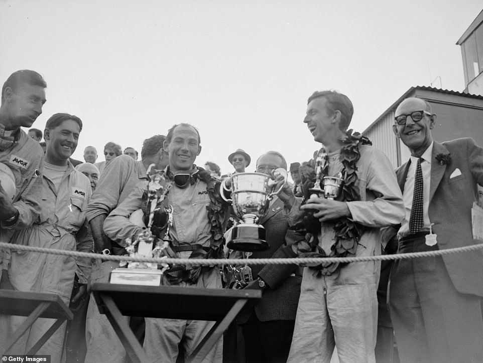 Moss (centre), celebrates with co-driver Tony Brooks (second right) after winning the 1958 Tourist Trophy Sports Car race.