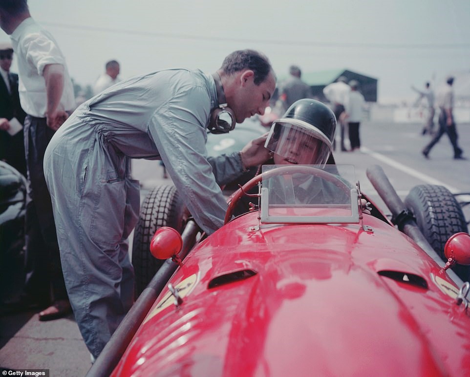 Moss adjusts the helmet of Ferrari rival Mike Hawthorn during the 1958 Formula One World Championship.