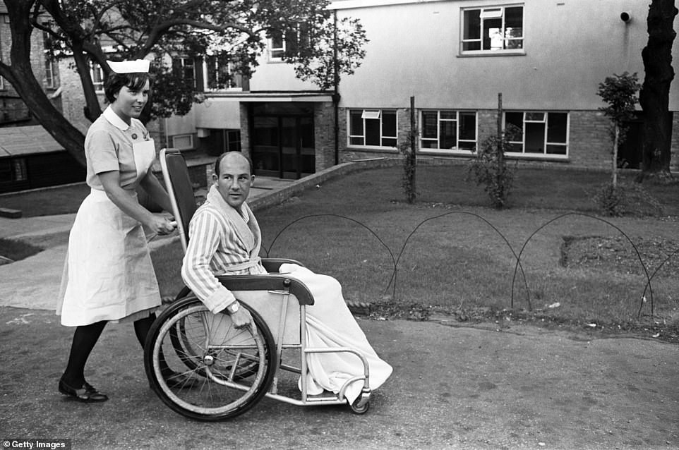 The ever-so popular British driver is pushed in a wheelchair at Atkinson Morley Hospital in Wimbledon after his crash.