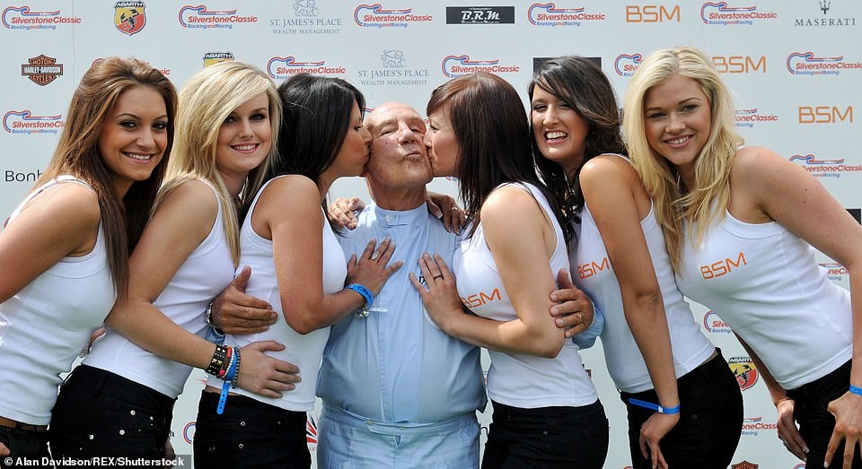 Moss poses for a picture with six grid girls at Silverstone Circuit in Northamptonshire, back in July 2010.