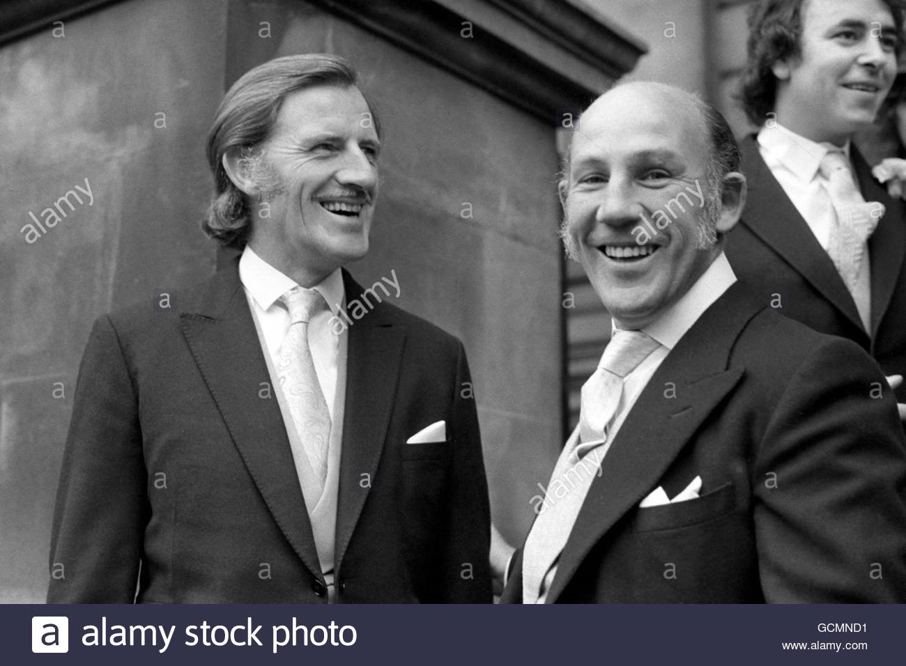 19 October 1974. Graham Hill (l) and Stirling Moss attend the wedding of another British driver, James Hunt. Hunt wed to model Suzy Miller at Brompton Oratory, London.