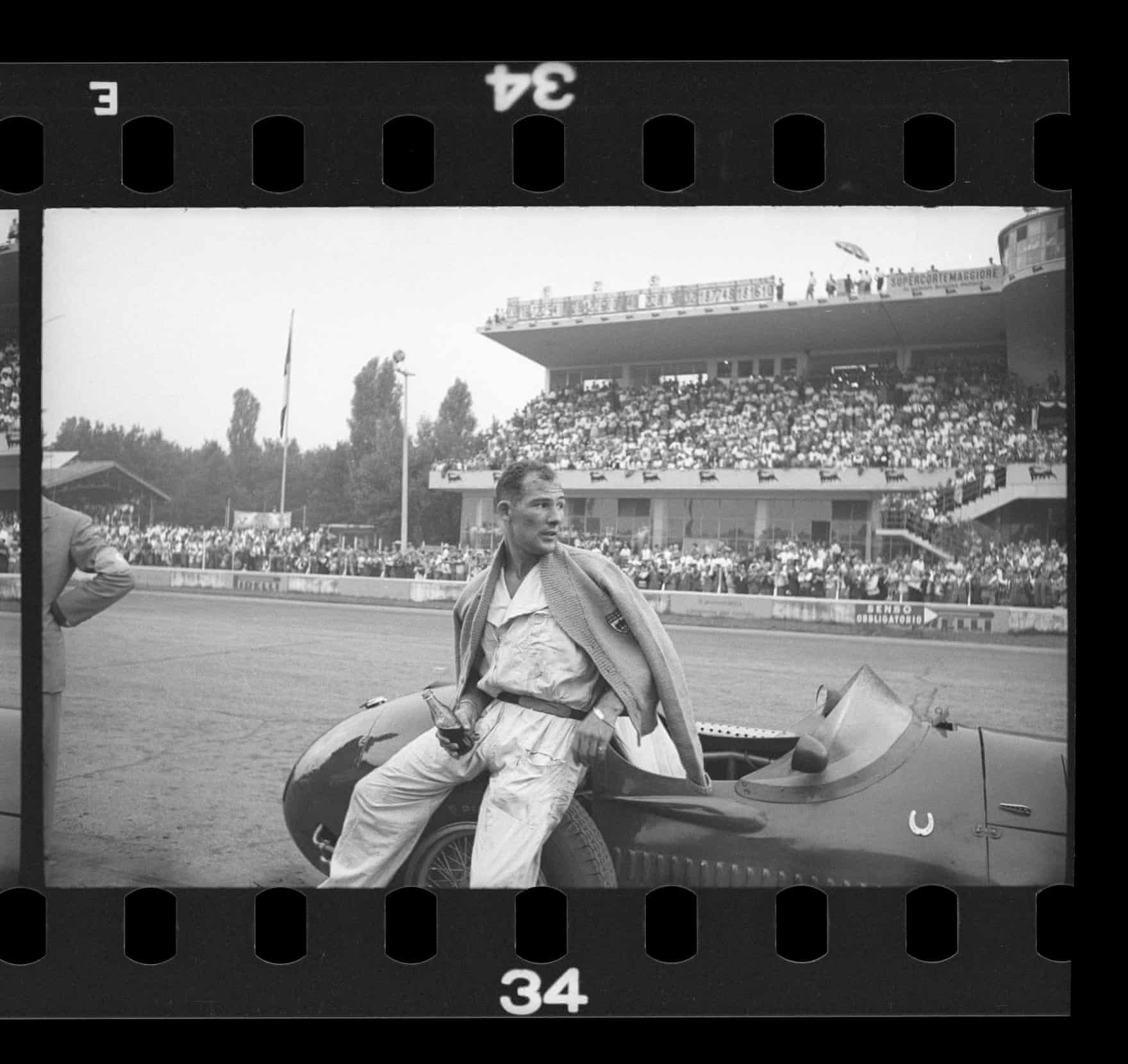 Moss drinks cola in the pits, after pushing his car past the finish line at the 1954 Italian Grand Prix.