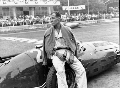 Moss drinks cola in the pits, after pushing his car past the finish line at the 1954 Italian Grand Prix.