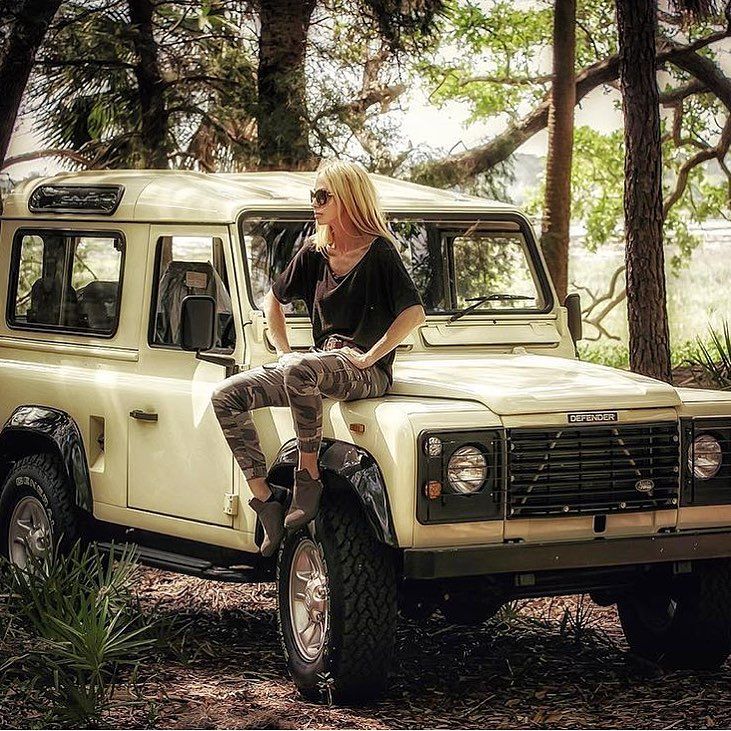 A blond girl on a Land Rover.