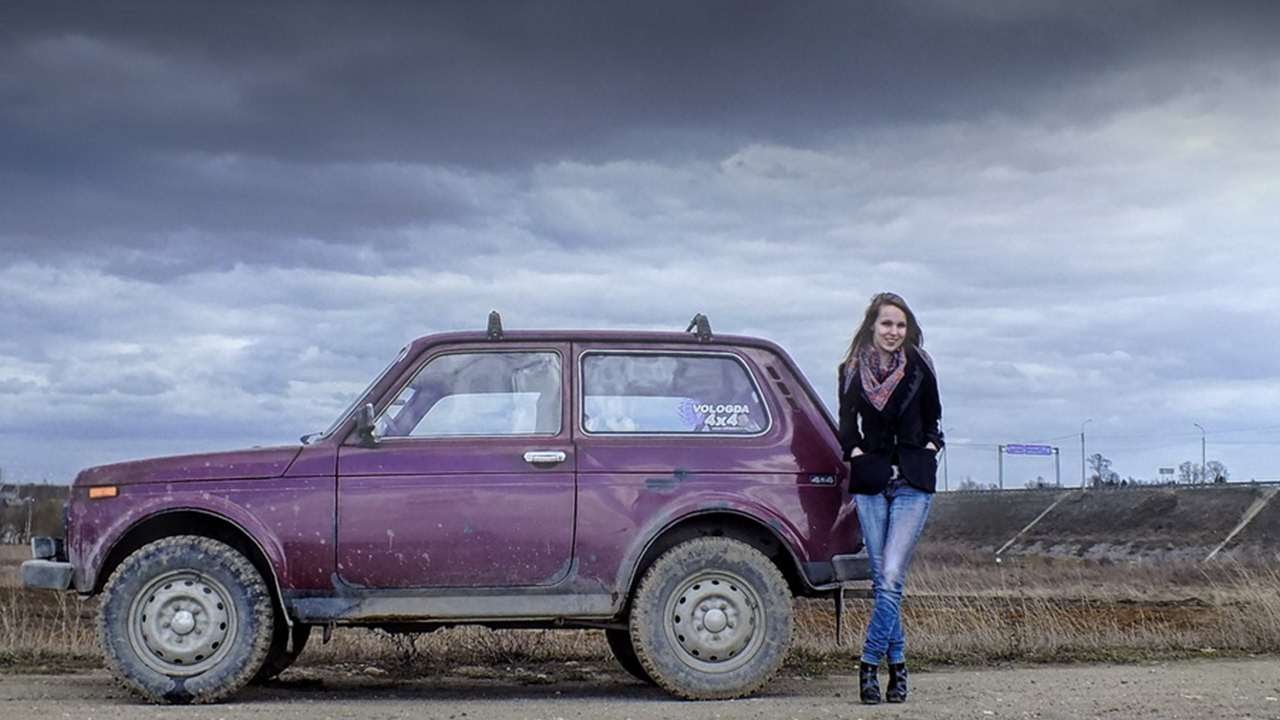 A girl and a violet Lada Niva.