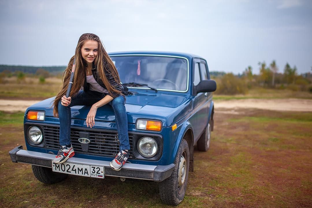 A girl on a blue Lada Niva.