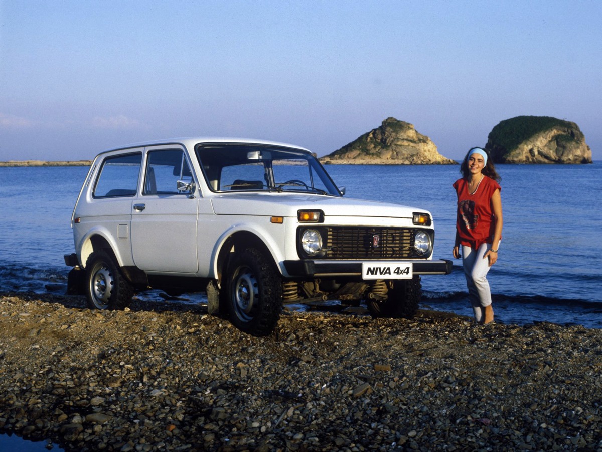 A girl and a white Lada Niva on the beach.