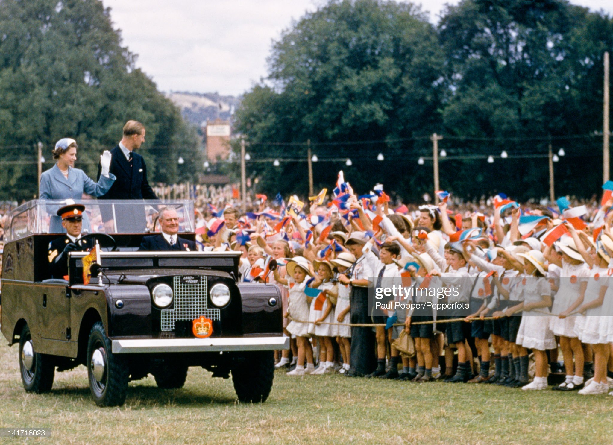 Queen Elizabeth II and Prince Philip waving to a crowd of children in Bathurst.