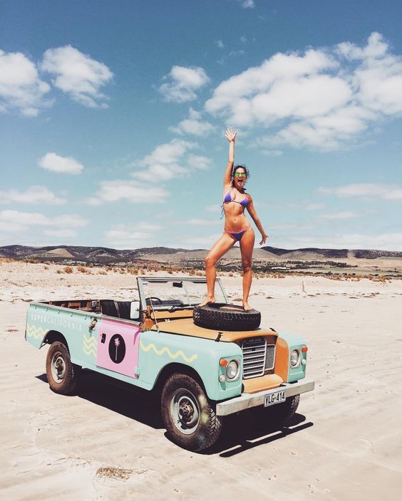 A girl in bikini on a Land Rover.