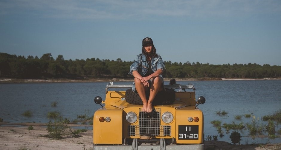 A girl on a yellow Land Rover.