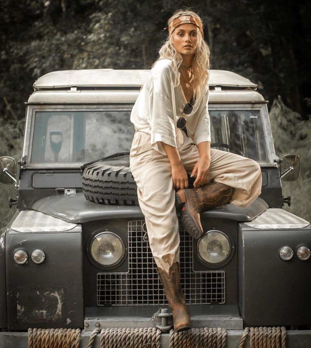 A blonde girl on a grey Land Rover.