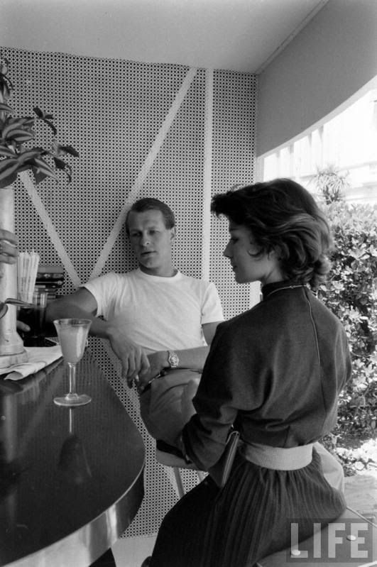 Peter Collins having a drink with a girl.