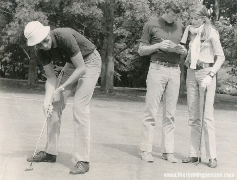 Piers Courage plays golf in Australia, watched by Jochen and Nina Rindt. 