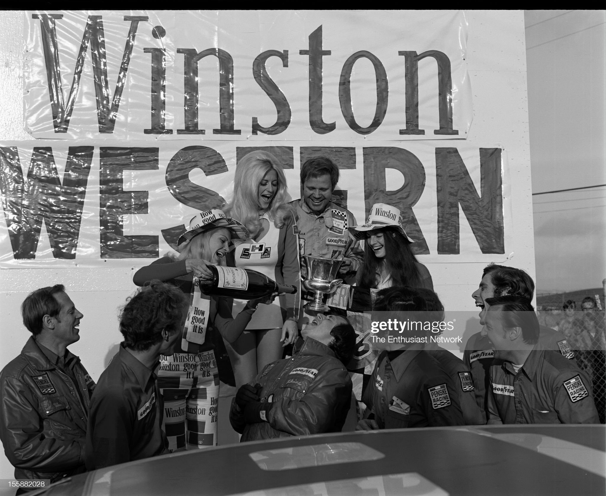 Race winner Mark Donohue and team celebrate with the Winston Western grid girls and Hurst model Linda Vaughn. 