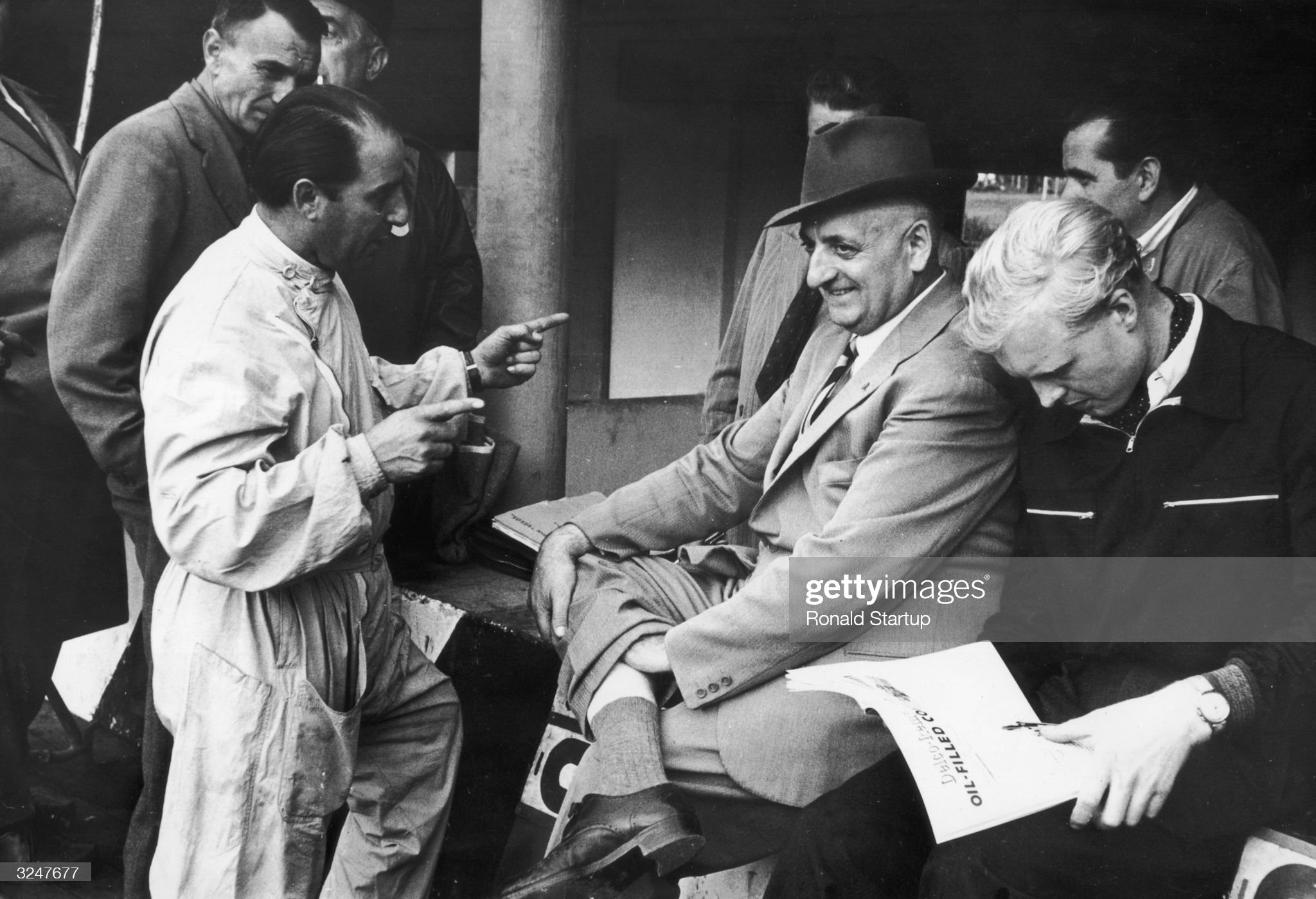 Enzo Ferrari, centre, in the Ferrari pits at Monza with Alberto Ascari, left and Mike Hawthorn, right, on 13th September 1953. 