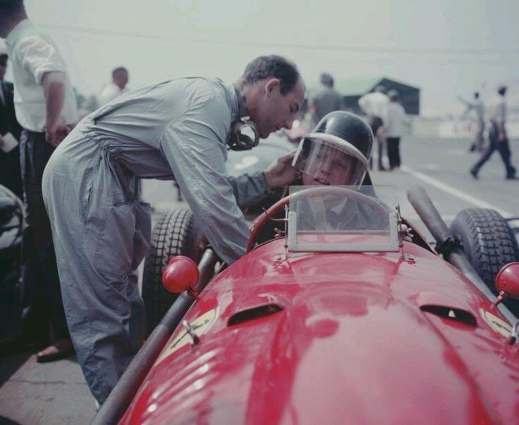 Stirling Moss fixes his friend and rival Mike Hawthorn's helmet in 1958.