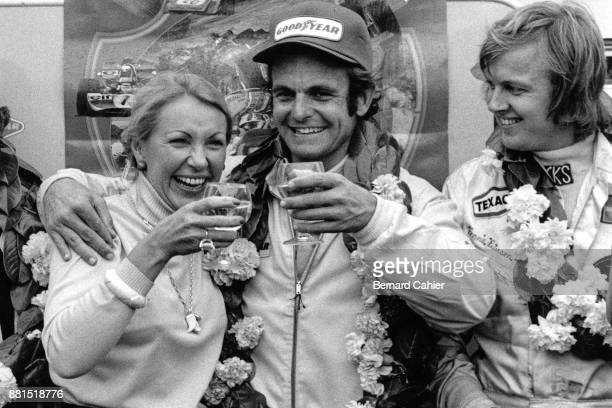 Peter Revson celebrating his victory in the British Grand Prix with Joan Cahier and Ronnie Peterson (who finished second), Silverstone Circuit, 14 July 1973. 