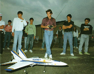 Ayrton with the controller in his hand and Fabio with his arms crossed on the right side, in Japan playing model airplanes in 1990.