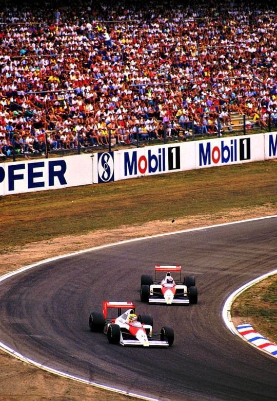 Ayrton Senna and Alain Prost on track, both driving a McLaren.