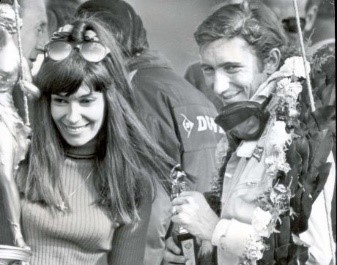 Jubilant winner Jo Siffert with a victory garland round his neck stands with his wife.