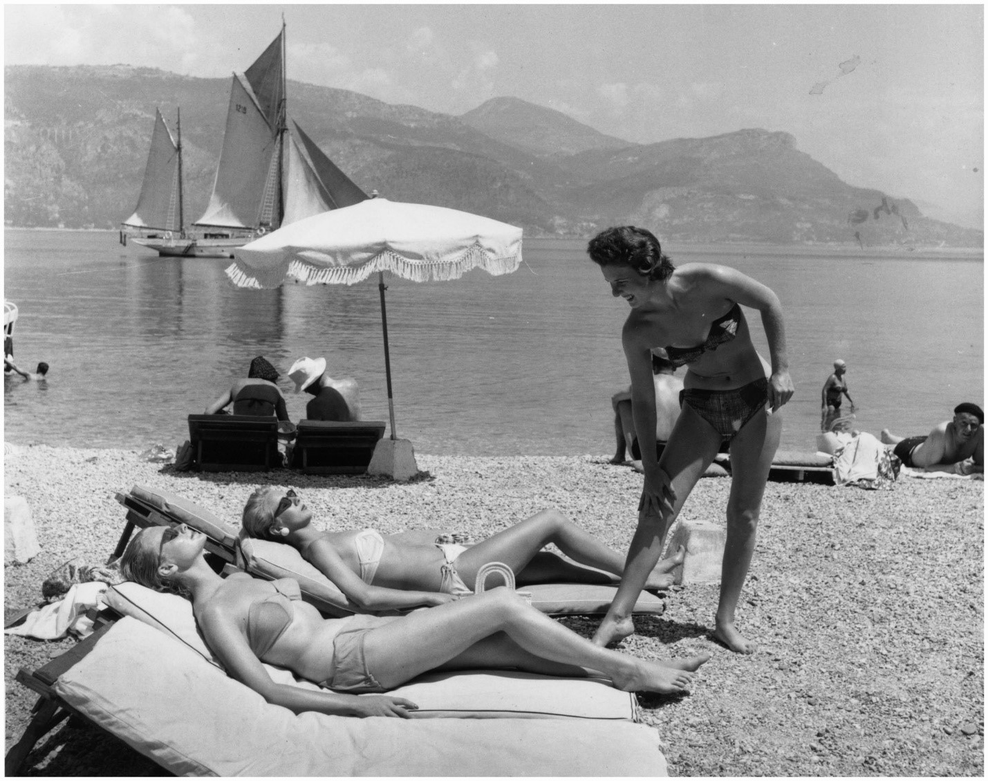 Three British models sunbathing on a beach on the Cote d’Azur during a cruise.