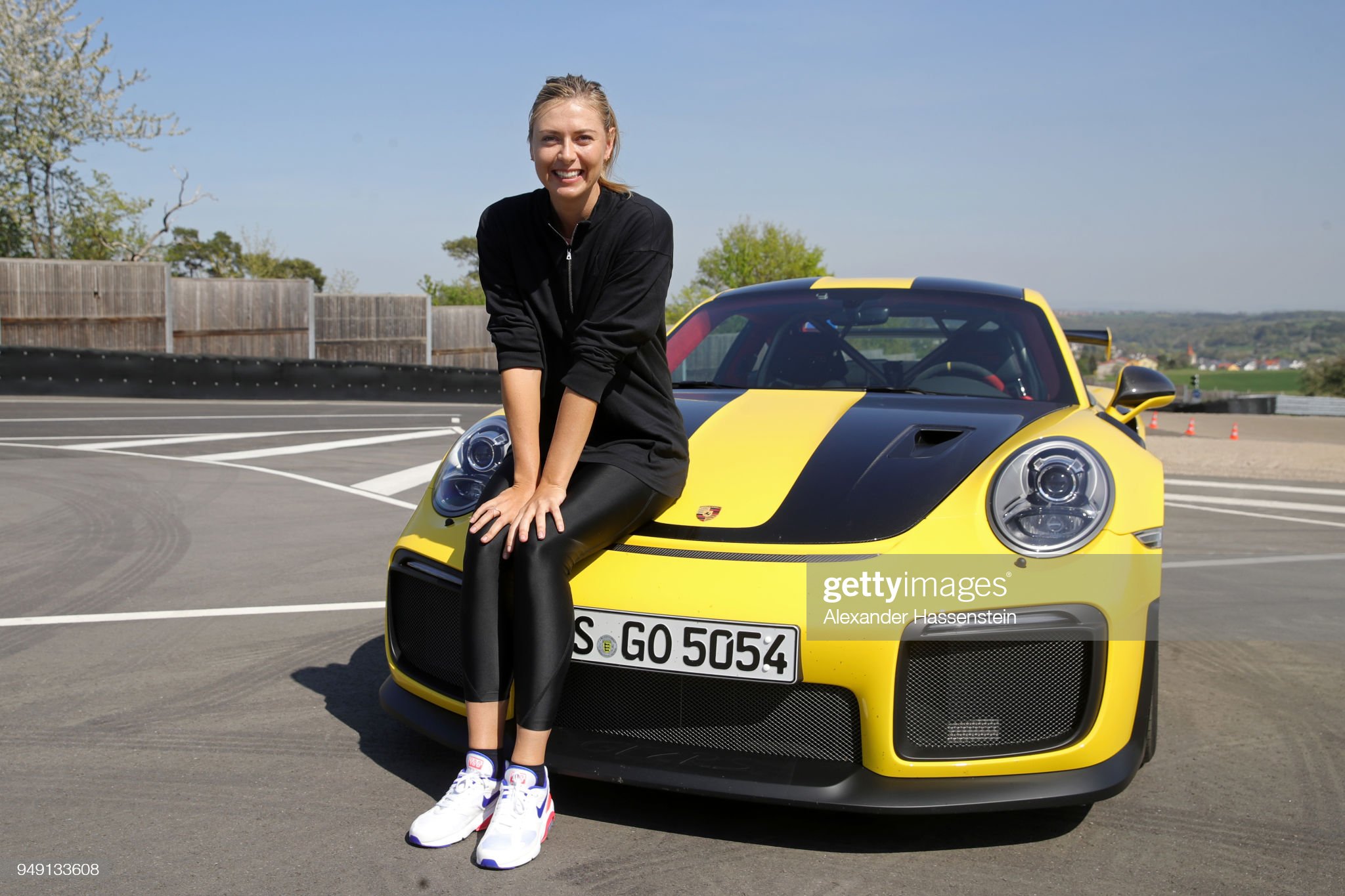 Maria Sharapova on a yellow and black Porsche 911 RT2 RS.