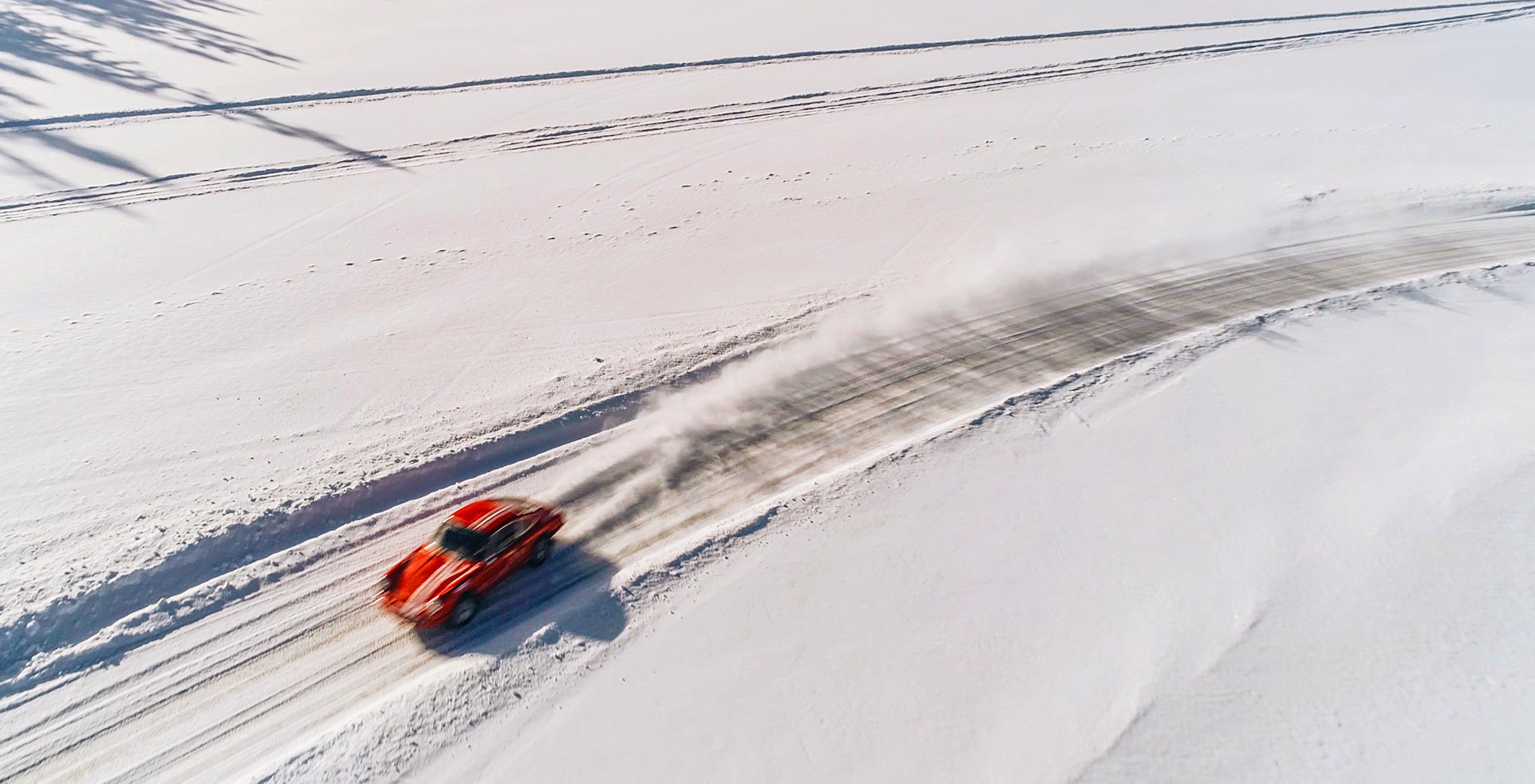 A red Porsche driven on the snow.