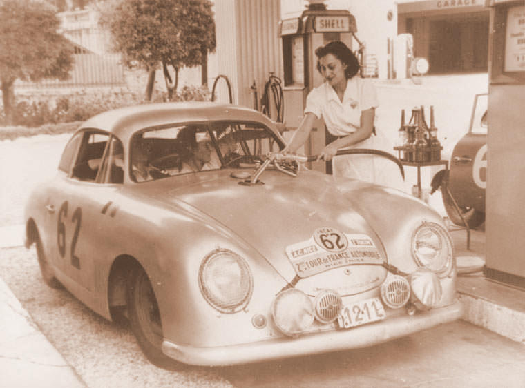 A girl is putting gas in a Porsche 356.
