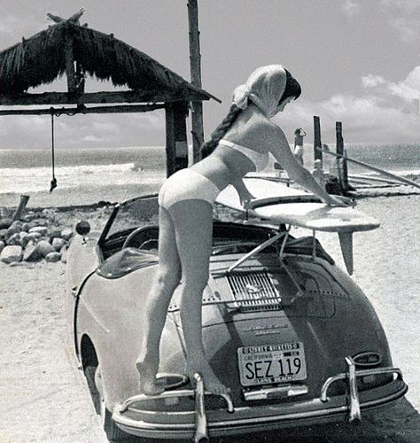 A girl in a bikini with a surf on a Porsche 356.