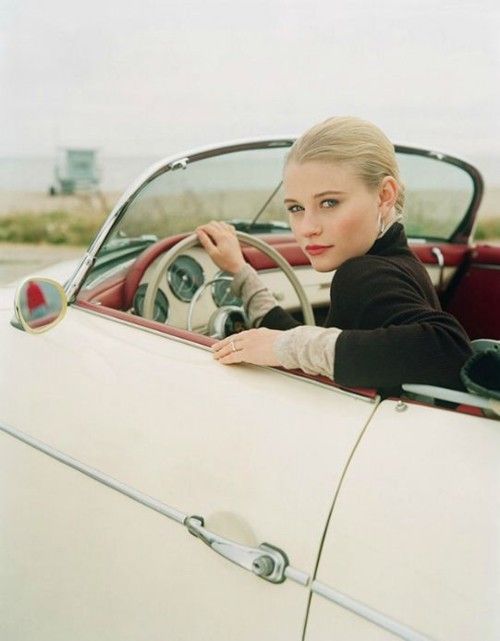 A blonde girl in a Porsche.