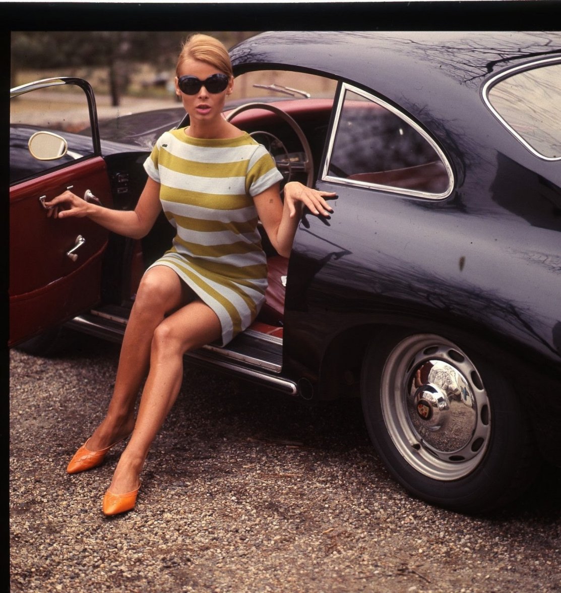 A girl in a black Porsche 356.