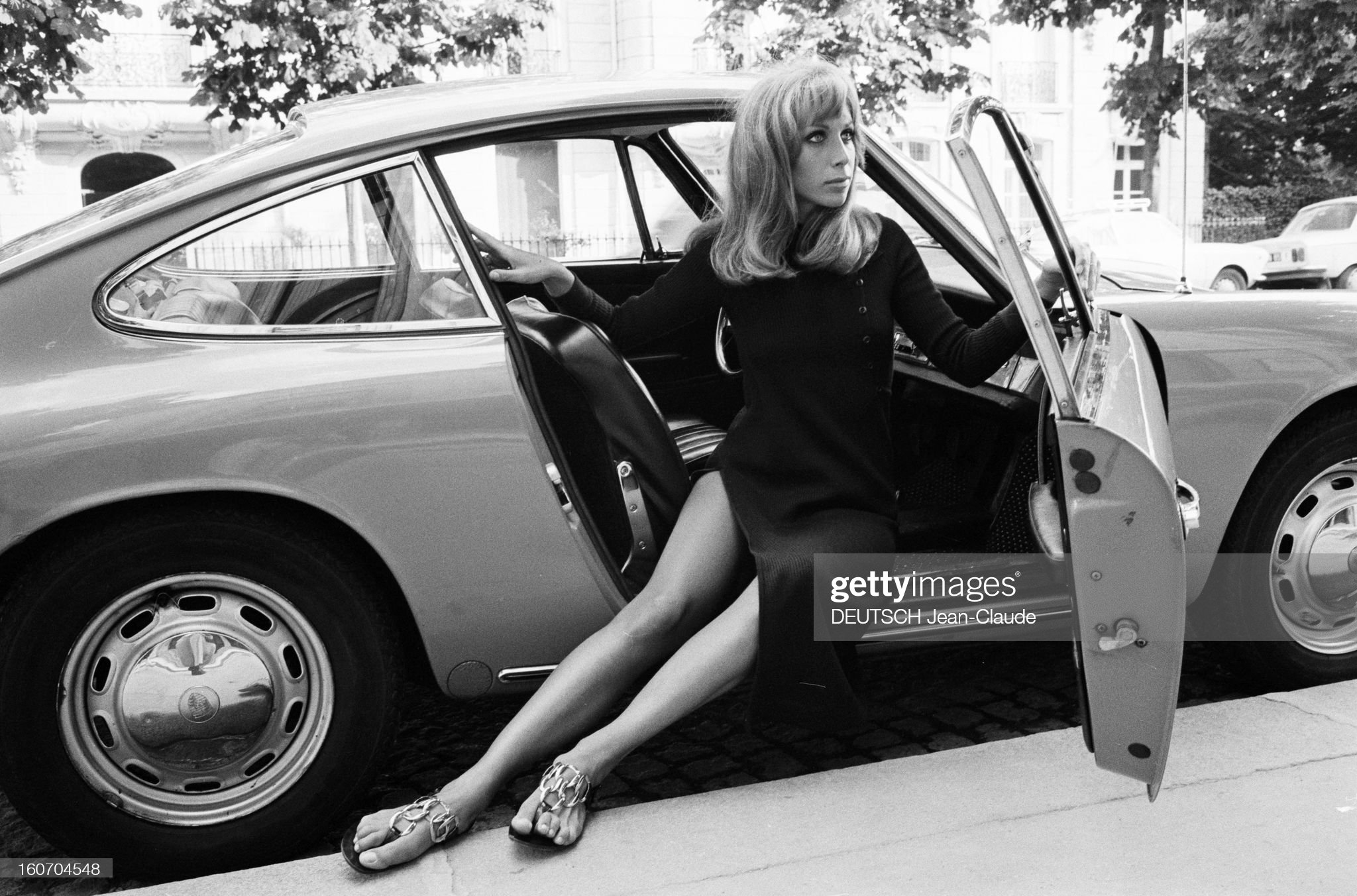 Paris, August 12, 1970. Tanya Lopert, American, posing seated on the front passenger side seat of a Porsche.