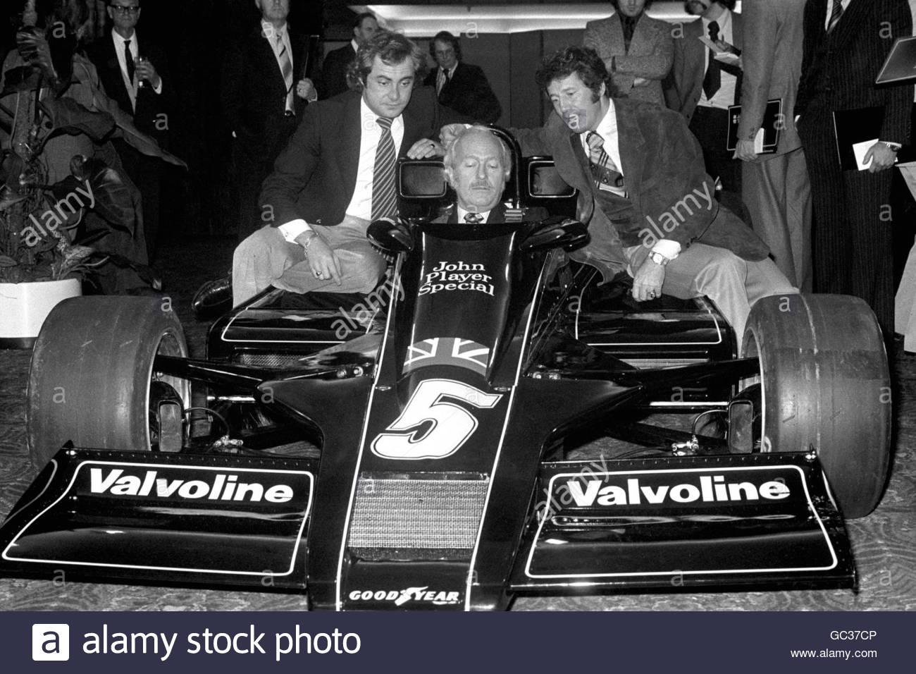 The new Lotus 78 (codenamed the John Player Special Mk. III) is unveiled to the media during its launch at London's Royal Garden Hotel. Lotus chief Colin Chapman sits in the new car, flanked by drivers Mario Andretti (right) and Gunnar Nilsson. December 21, 1976.