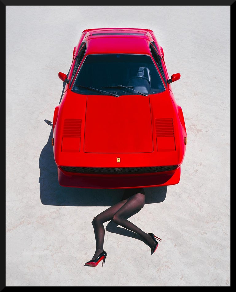 Sexy legs under a red Ferrari.