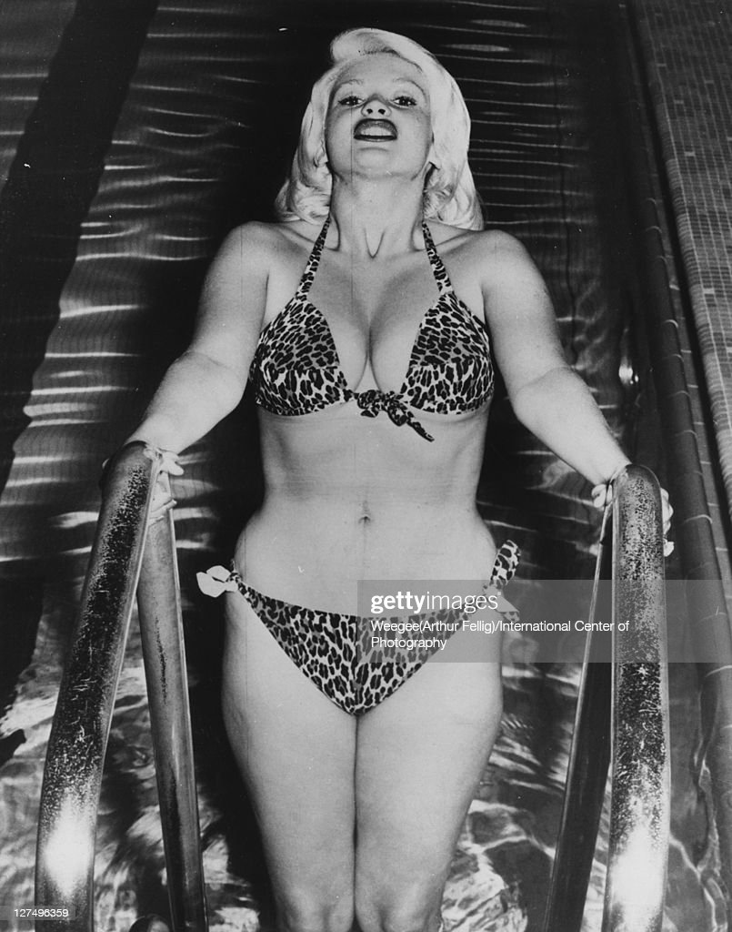 Portrait of American actress Jayne Mansfield (born Vera Jayne Palmer, 1933 - 1967) as she holds onto a swimming pool ladder dressed in a leopard-print bikini, 1955. 