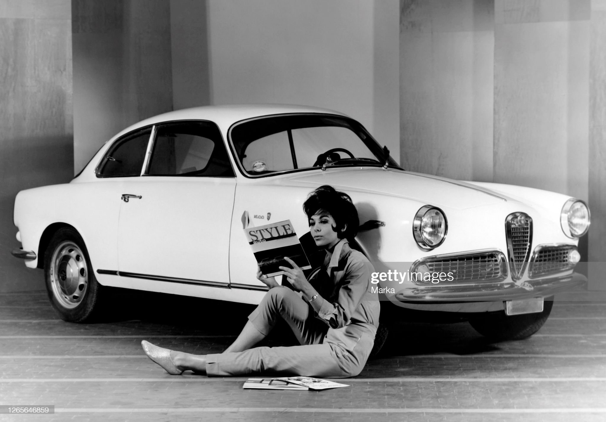 A woman in front of an Alfa Romeo Giulia Sprint Coupe, cab Bertone, in 1963.