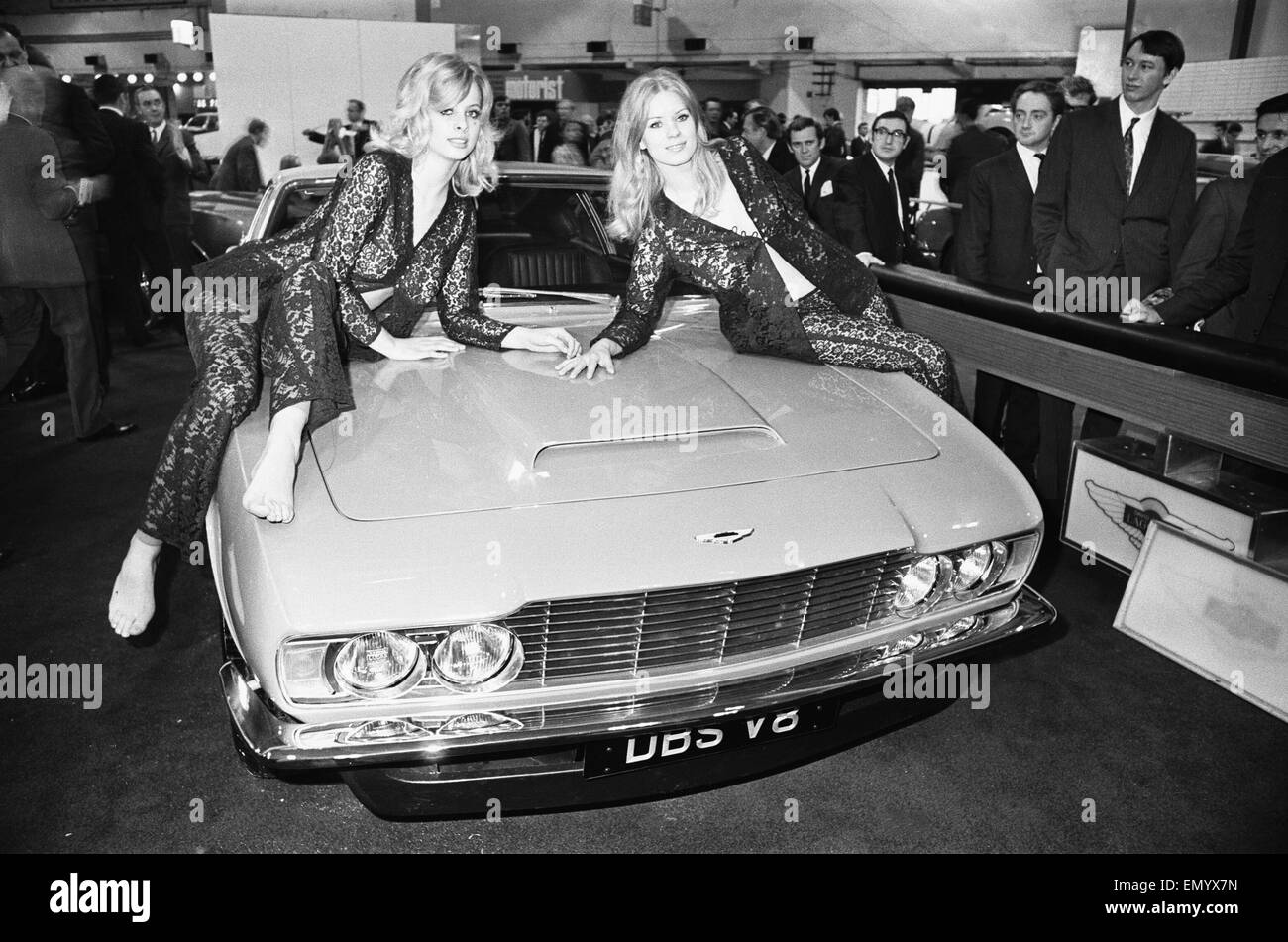 Models drapped over the bonnet of an Aston Martin DBS V8 at the 1969 Motor Show on 1st June 1969. 
