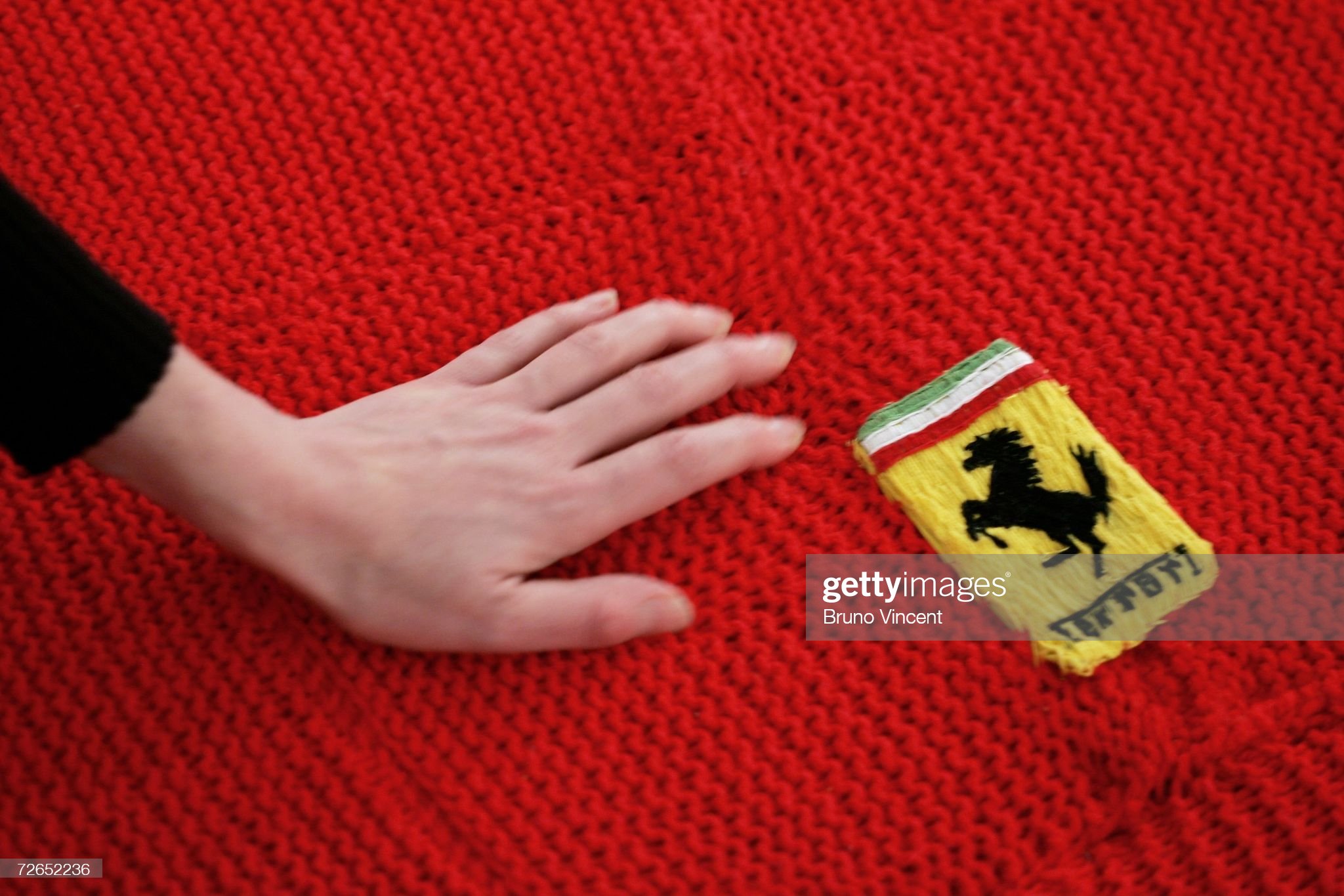 A woman strokes the threads of an entirely knitted full size replica Ferrari sports car on show in a gallery on November 27, 2006 in London, England.