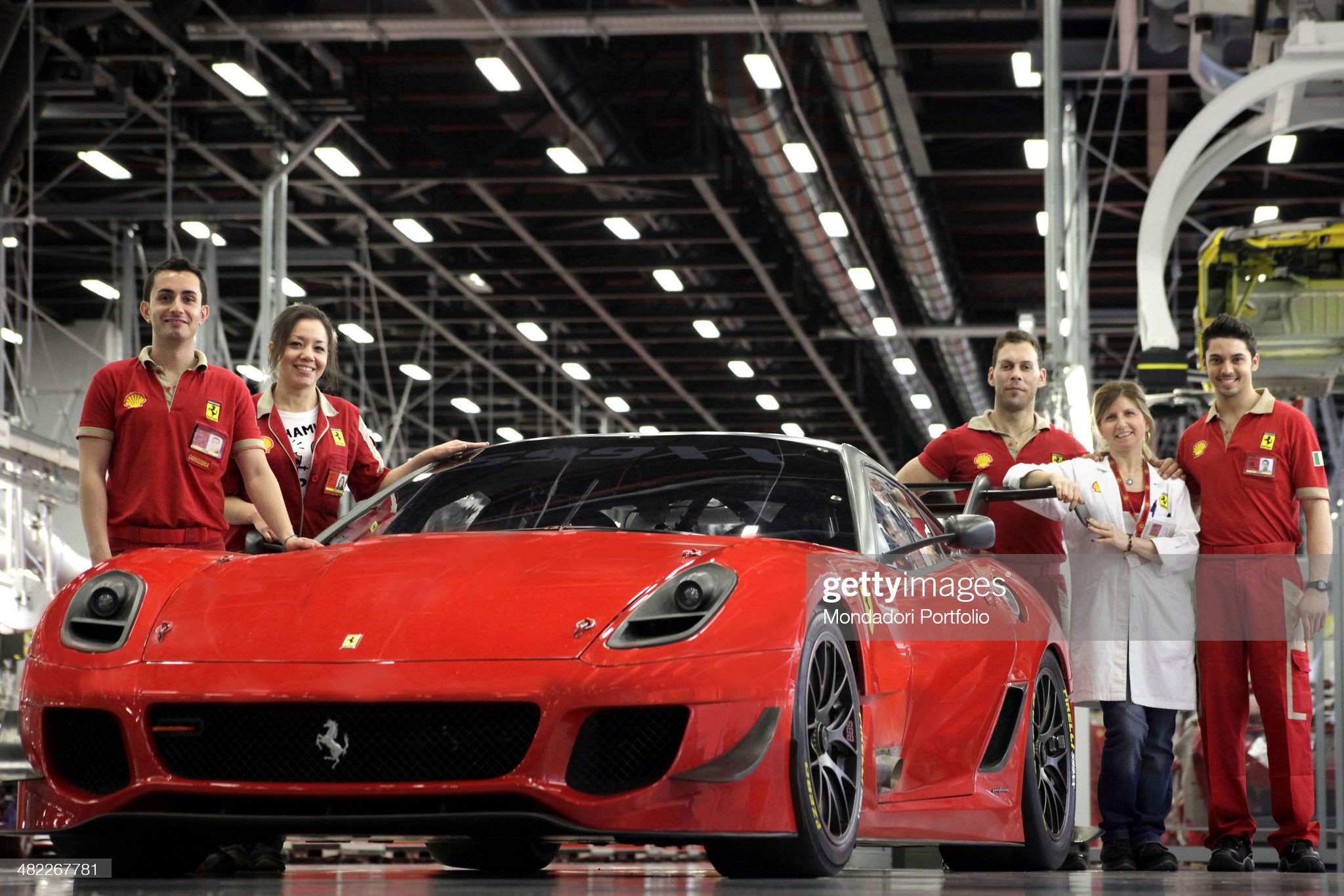 Workers of Ferrari pose next to a Ferrari 599XX on June 04, 2012.