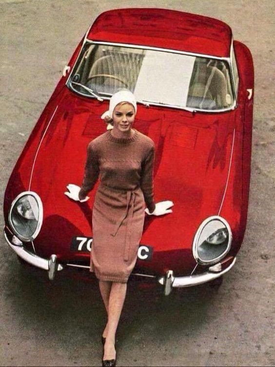 A vintage girl on a red car.