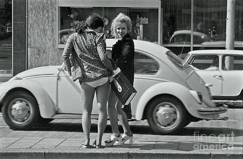 Two girls in front of a Wolkswagen Beetle.