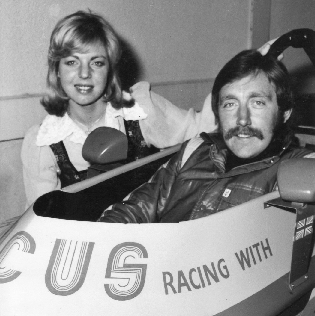 In the photo you can see not only Ann Moore but the one attachment that you needed in the seventies as a race driver … a meaningful moustache! Ann is with Brian Sims in UK in 1976.