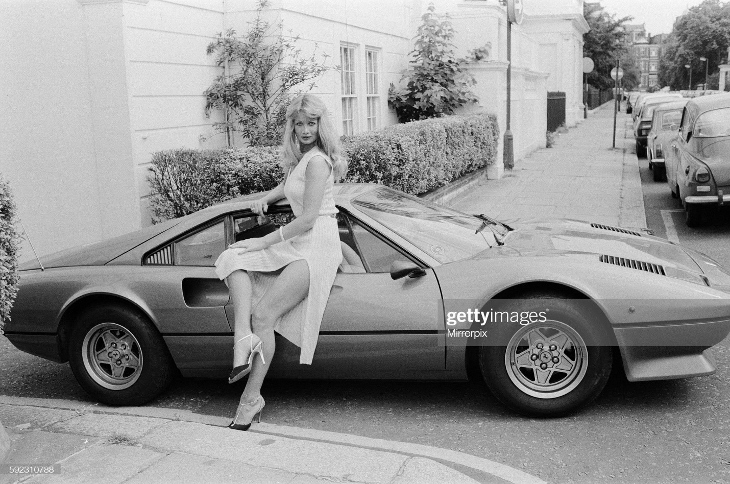Glamour model Tina poses next to a Ferrari 308 GTB on 11 July 1979. 