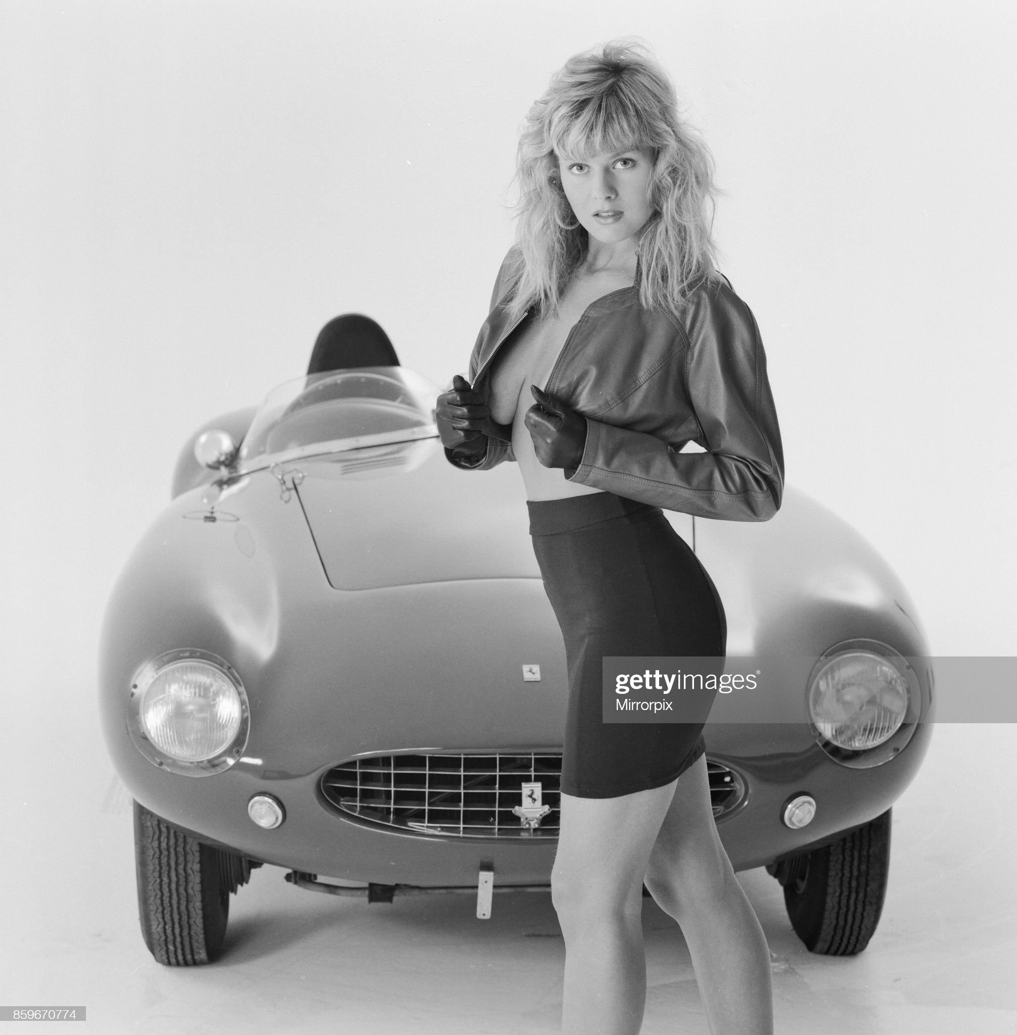 Glamour model Caroline Delahunty poses in front of a Ferrari, 19th April 1988. 