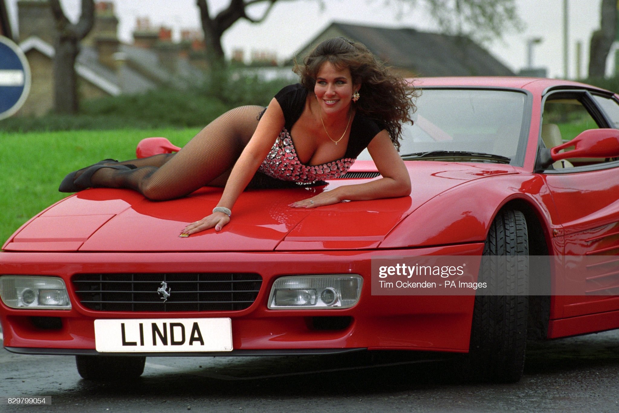 Lying on a Ferrari, Linda Lusardi poses with the number plate L1 NDA, which is to be auctioned at the DVLA classic collection sale, on October 01, 1993. 