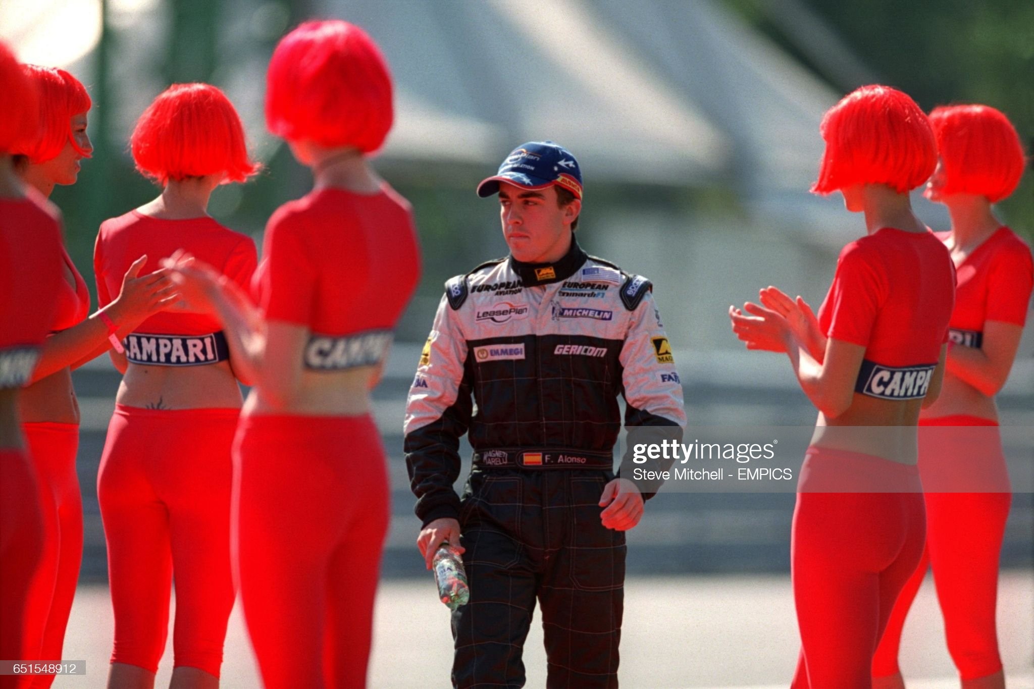 Minardi's Fernando Alonso walks between the grid girls at Monza on September 16, 2001. 
