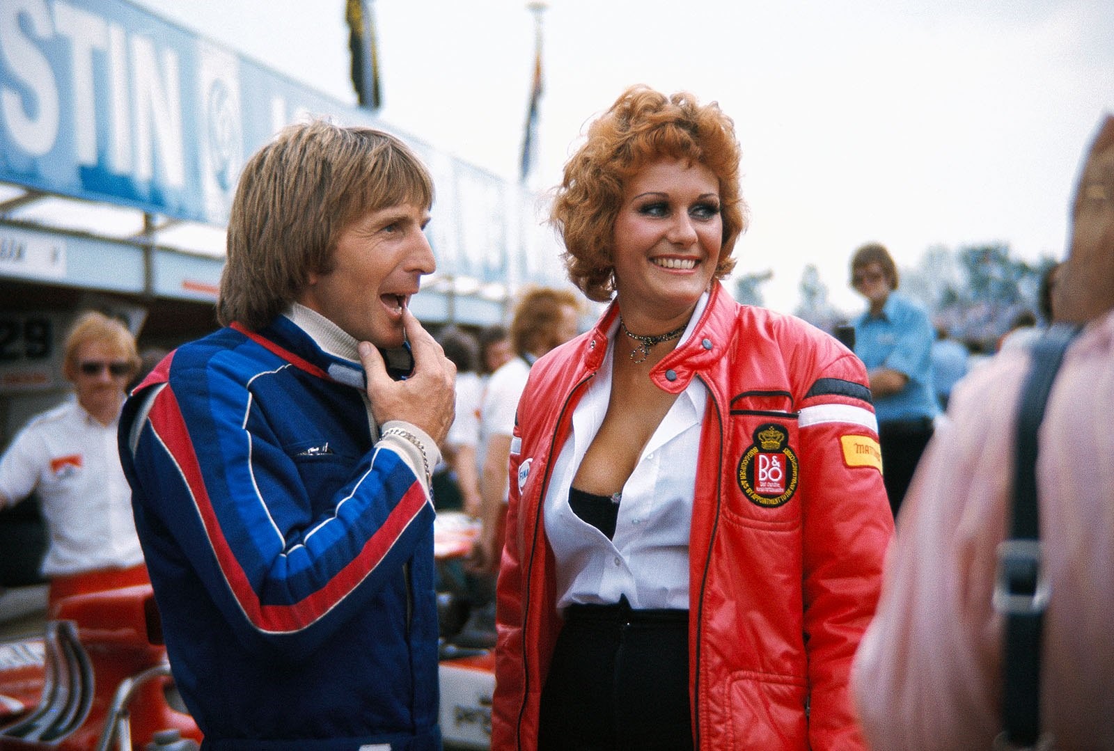 Derek Bell with an unknown beauty in the pit lane before the 1974 British Grand Prix. 