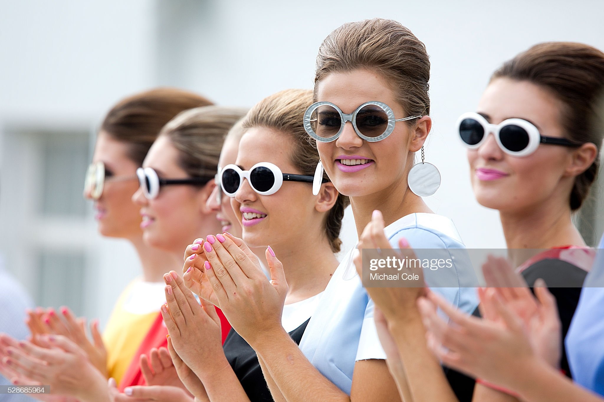 Grid girls wearing period sunglasses trackside at Goodwood Revival on September 12, 2015. 