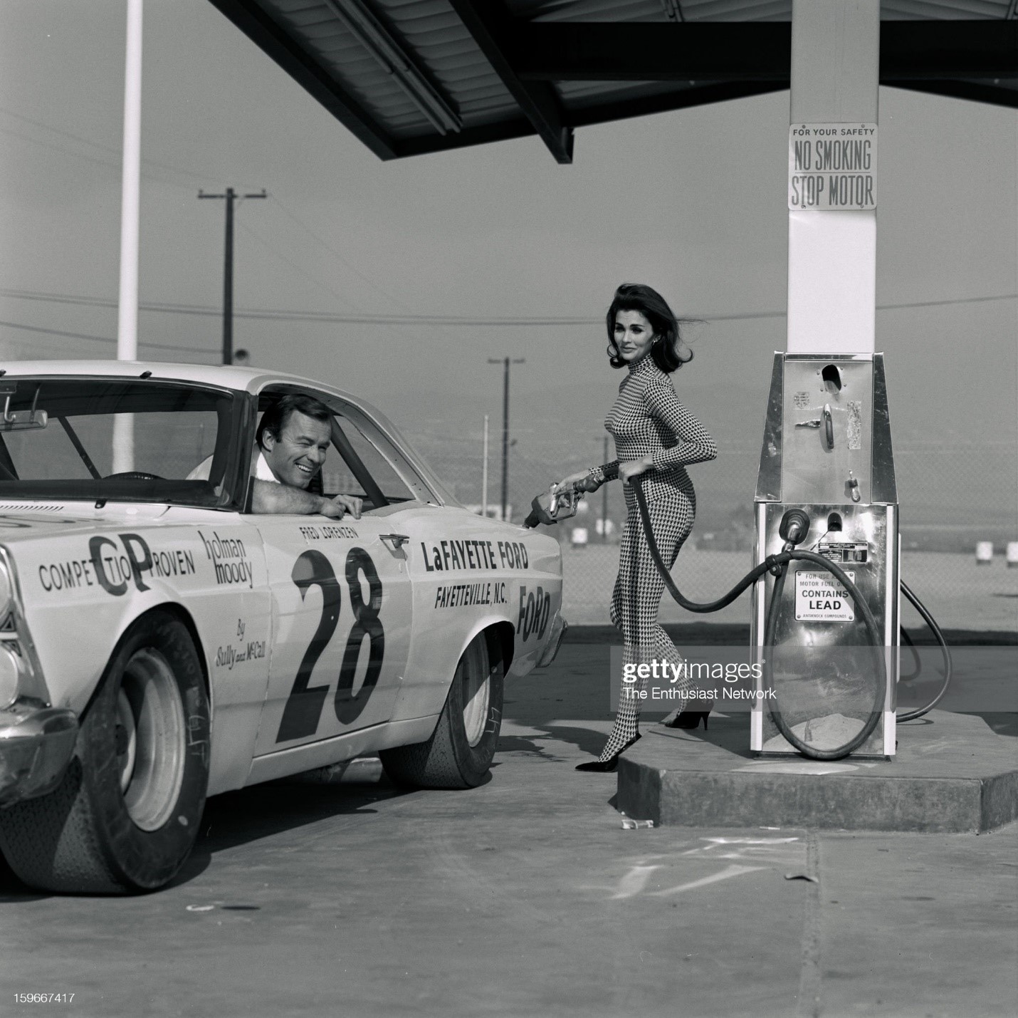United States, January 05, 1967, Queen Motor Trend 500. Race queen and actress Lara Lindsay poses for a shot filling up Fred Lorenzen's car. Lorenzen was in the race lead before the race was postponed. 